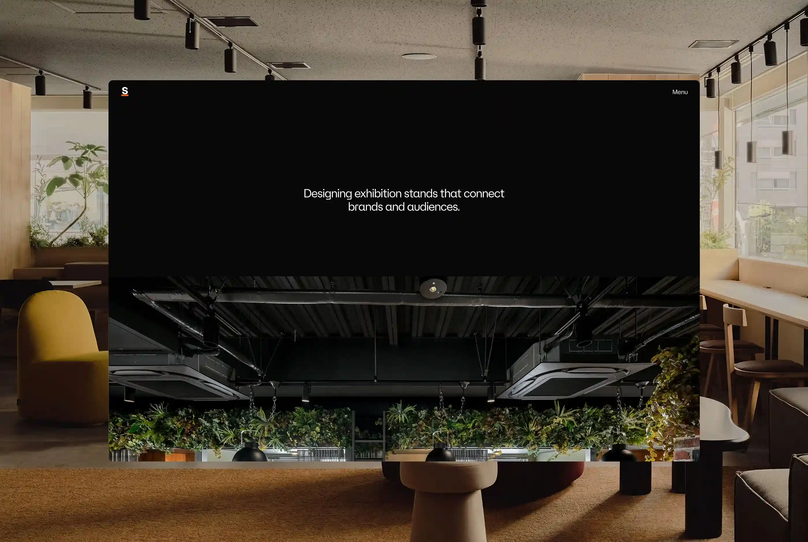 Brick house with a thatched roof surrounded by grass and bushes.